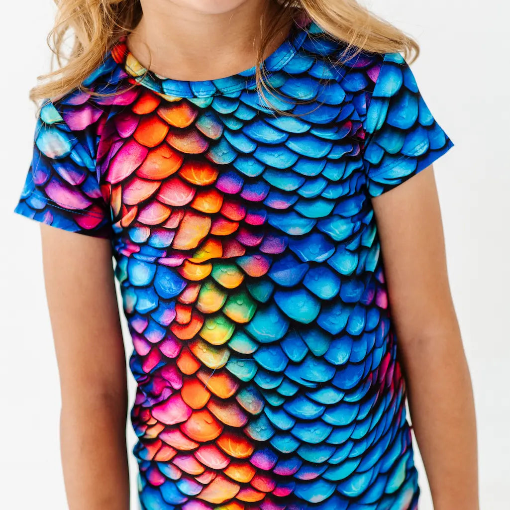 T-shirt with colorful scale pattern on a plain background