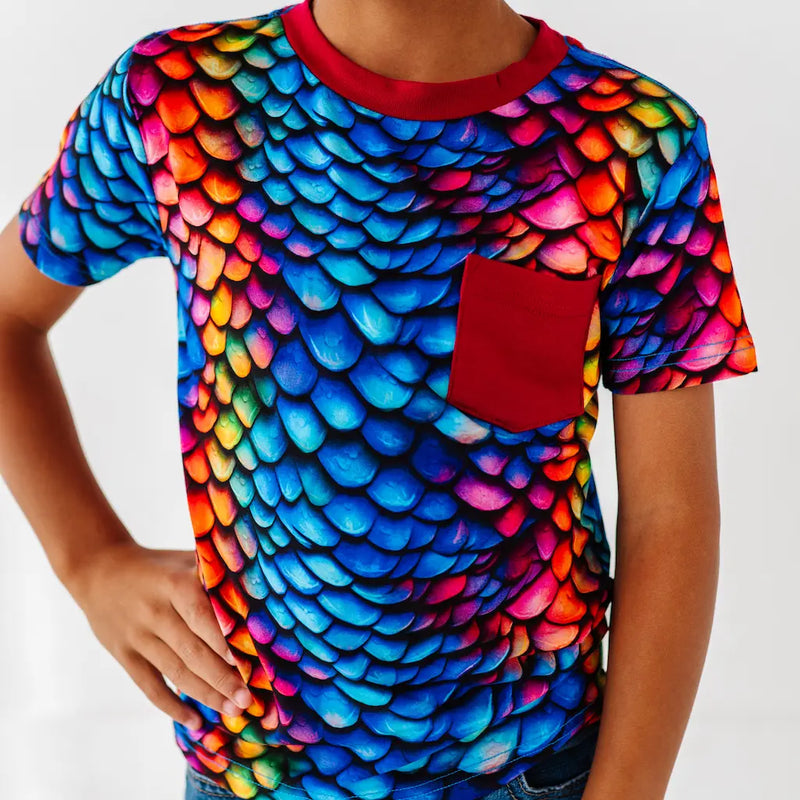 Colorful dragon scale pattern t-shirt with a red pocket on a plain background