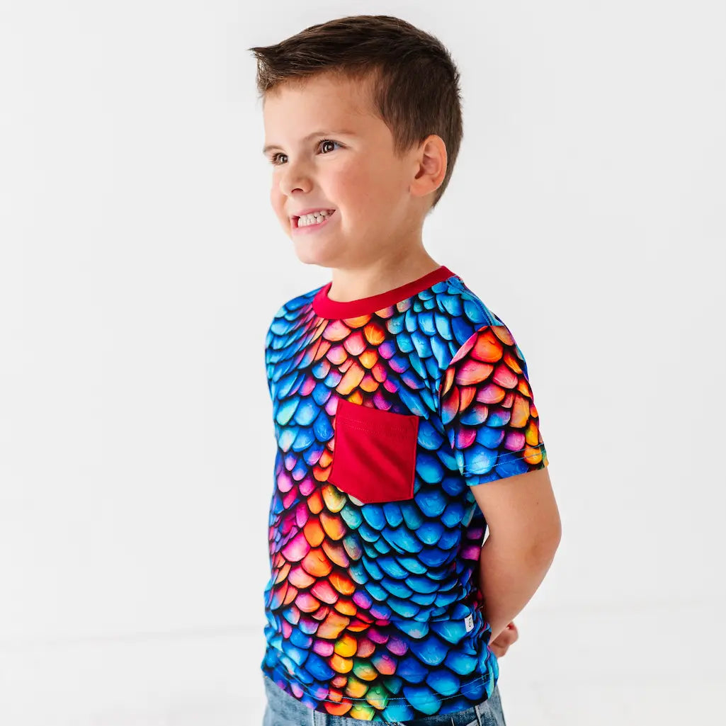 Child wearing a colorful shirt with a red pocket on a white background