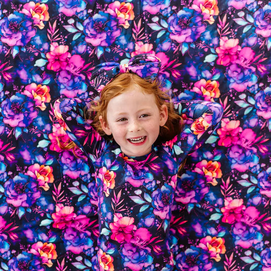 Child smiling in a colorful floral patterned setting