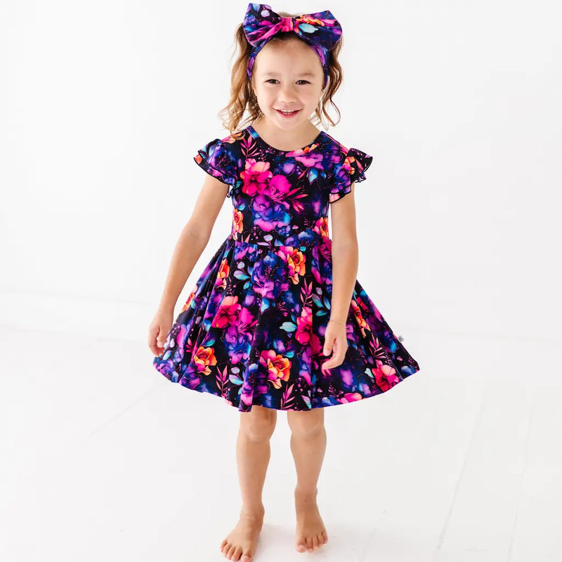 Person wearing navy leggings with colorful celestial and floral pattern on a white background