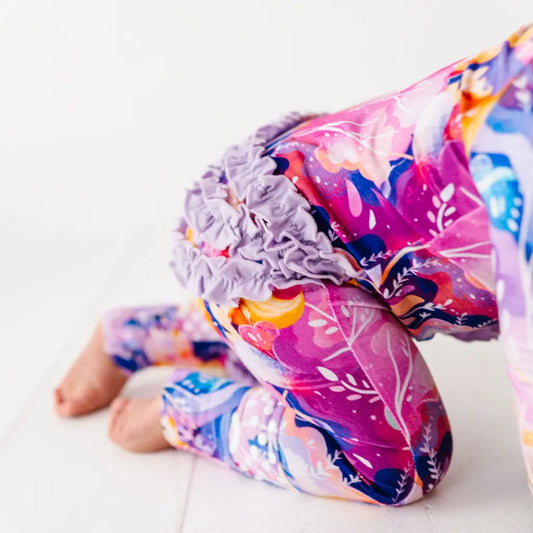 Colorful leggings with floral pattern and purple flower on a white background