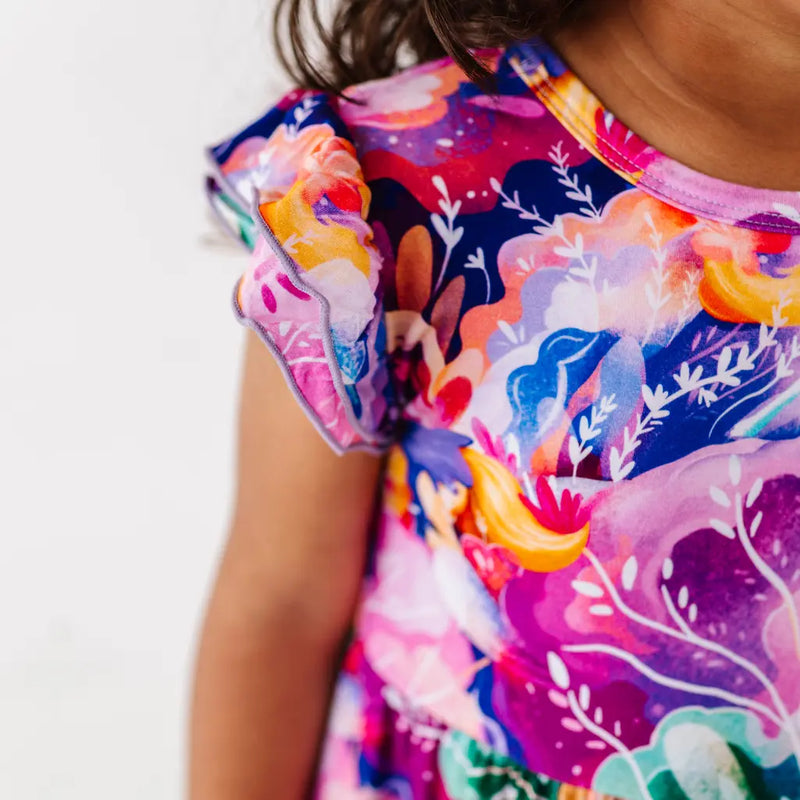 Colorful floral dress with ruffled sleeves on a plain background