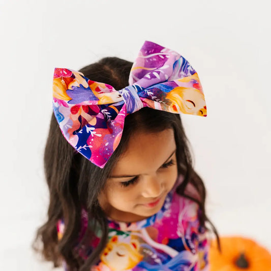 Child wearing a colorful headband with a large bow on a white background