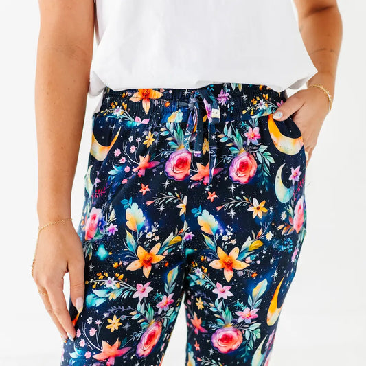Navy blue pants with colorful floral and moon designs worn by a person.