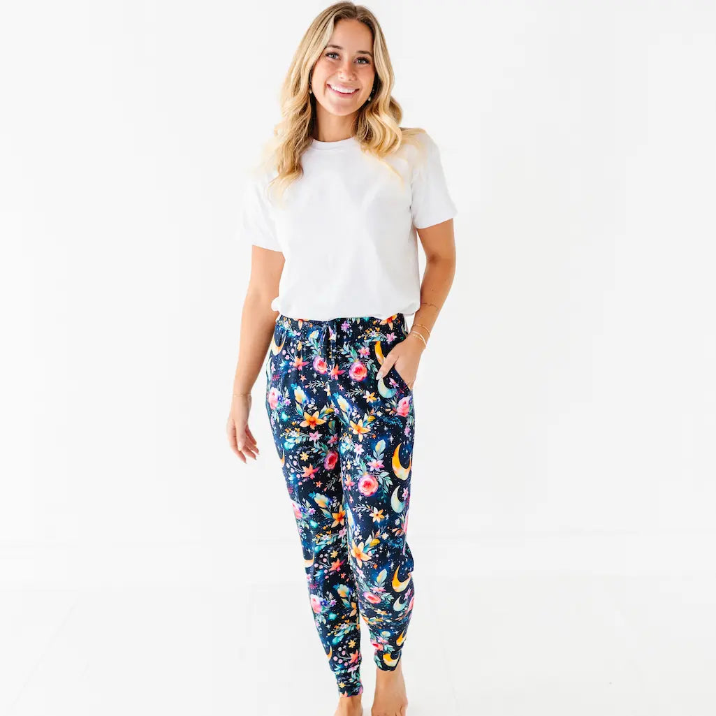 Woman wearing a white t-shirt and colorful patterned pants on a white background