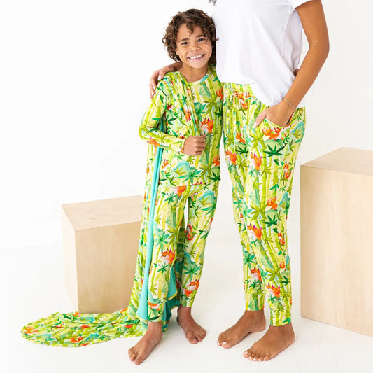 Two children wearing matching tropical-themed pajama sets on a white background