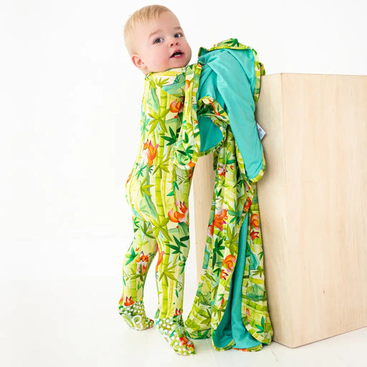 Baby wrapped in a colorful swaddle with a white background