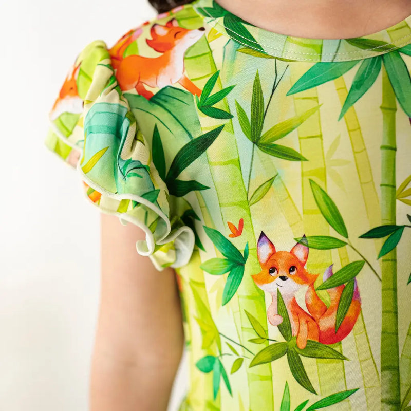 Close-up of a dress with fox and bamboo pattern on a white background