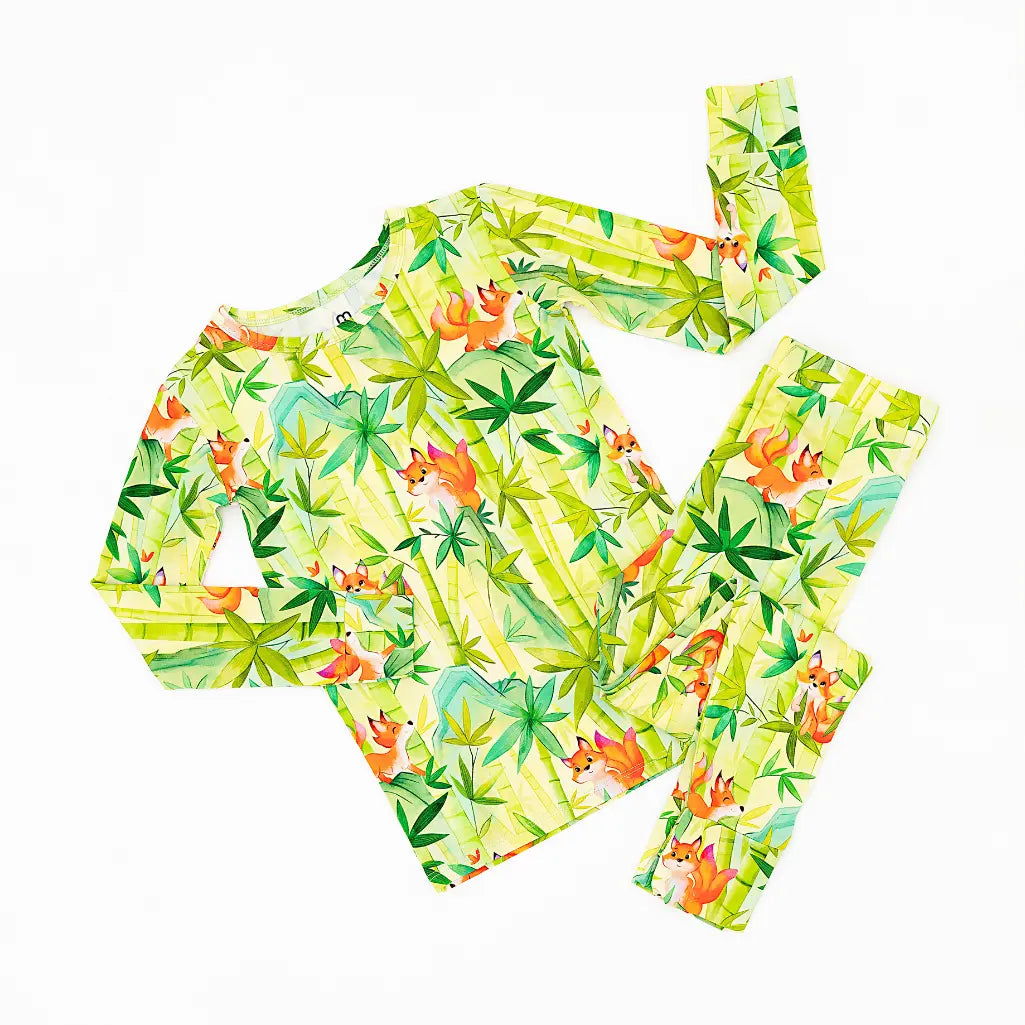 Two-piece swimsuit with tropical leaf pattern on a white background
