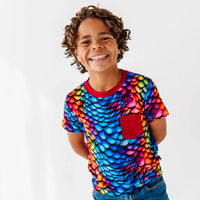 Child wearing a colorful shirt with a white background