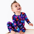 Child wearing a colorful onesie with a jellyfish pattern on a white background