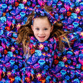 Child surrounded by colorful jellyfish pattern