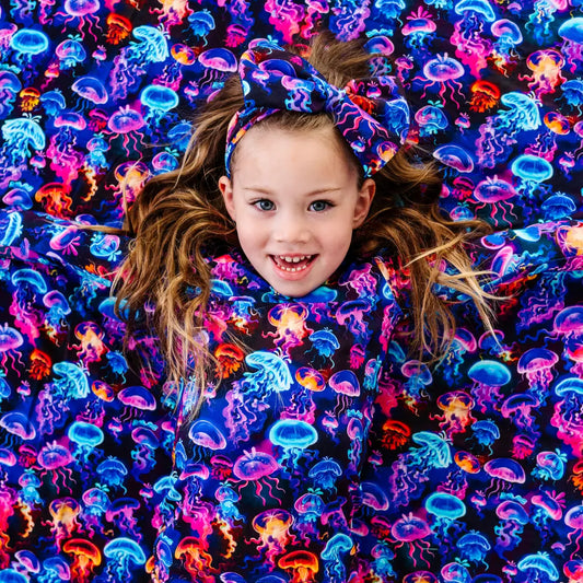 Child surrounded by colorful jellyfish pattern