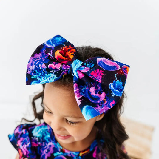 Child wearing a large, colorful floral headband with a white background