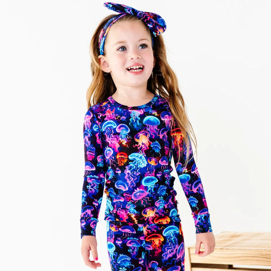 Child wearing a colorful jellyfish-themed outfit on a white background
