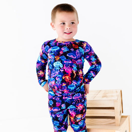 Child wearing a colorful onesie with jellyfish pattern on a white background