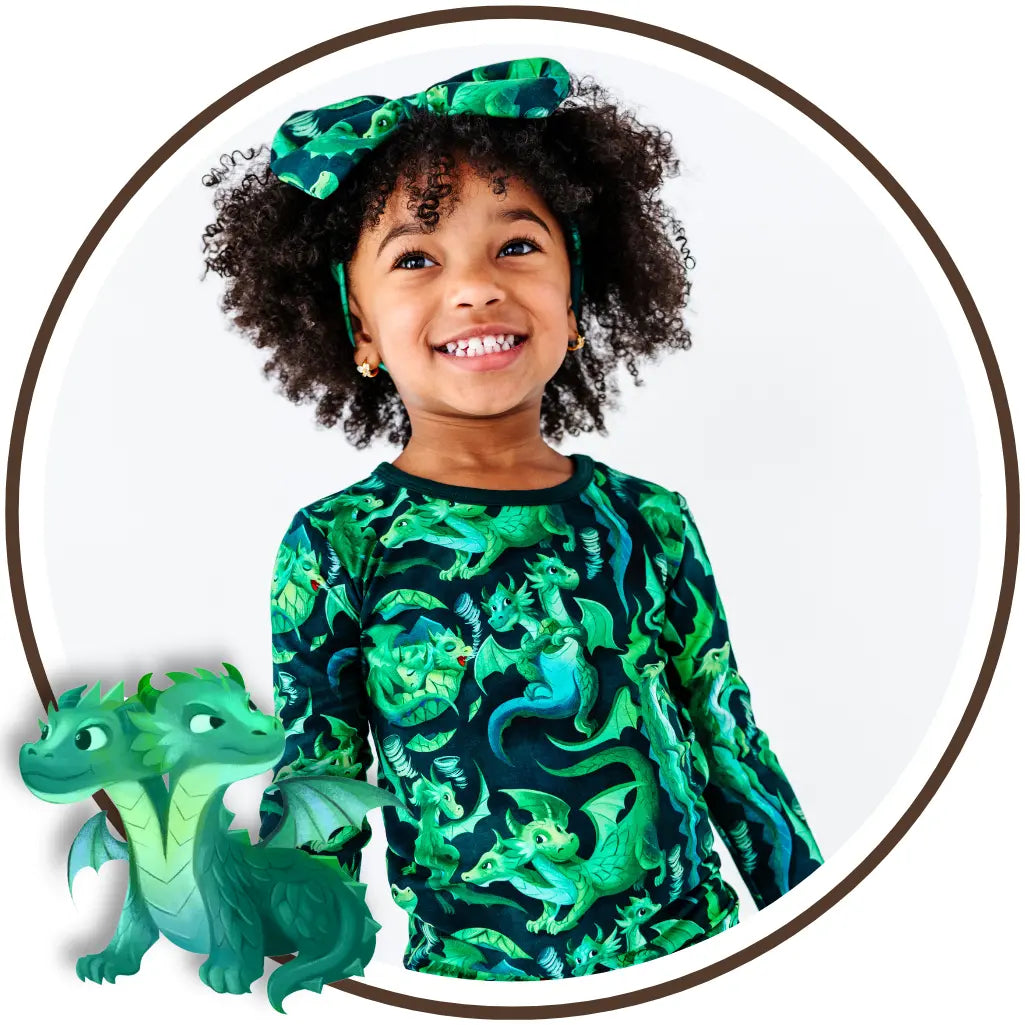 Child wearing a green dragon-patterned shirt with a toy dragon next to them, all set against a white background.