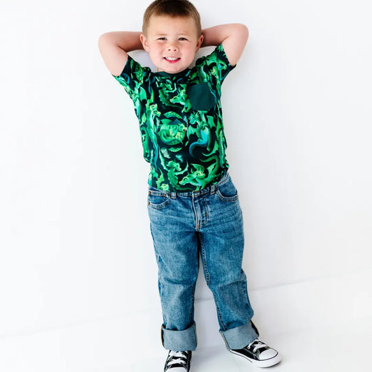 Child wearing a green camouflage shirt and blue jeans on a white background
