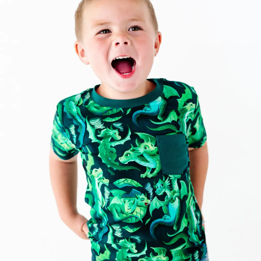 Child wearing a green dragon-patterned shirt on a white background