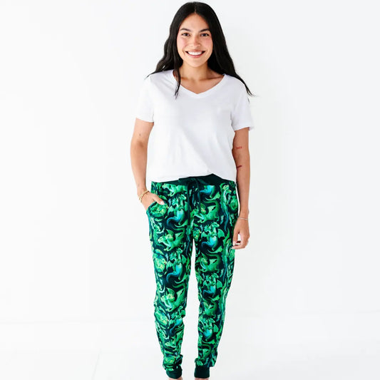 Person wearing a white t-shirt and green patterned pants on a white background
