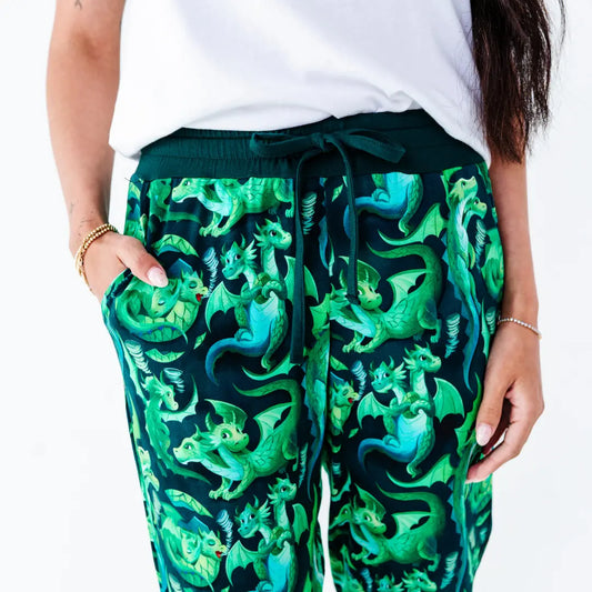 Green dragon-patterned pants worn by a person on a white background
