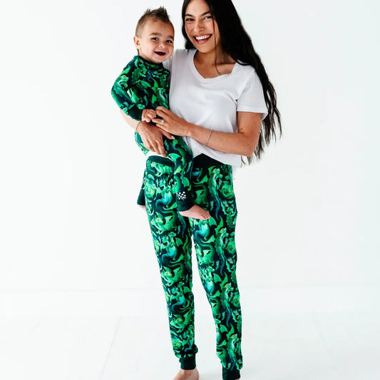 Woman and child wearing matching green camouflage outfits on a white background