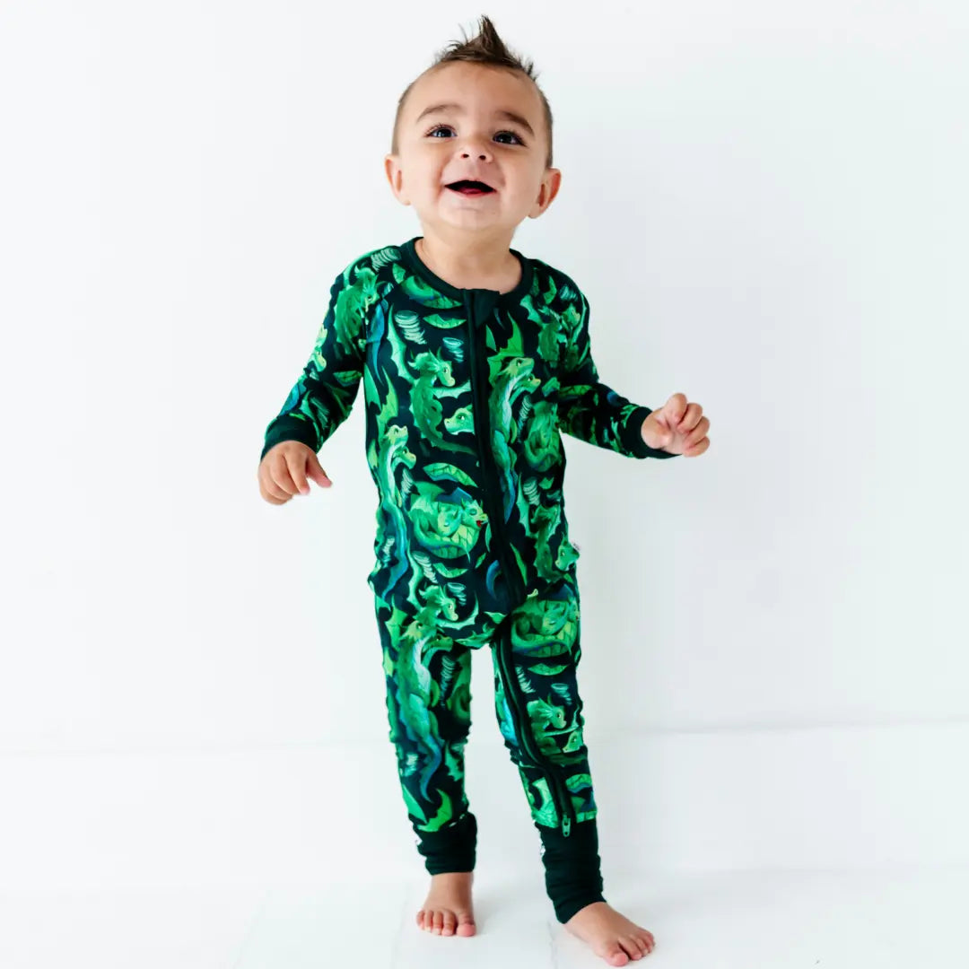 Child wearing a green camouflage onesie on a white background