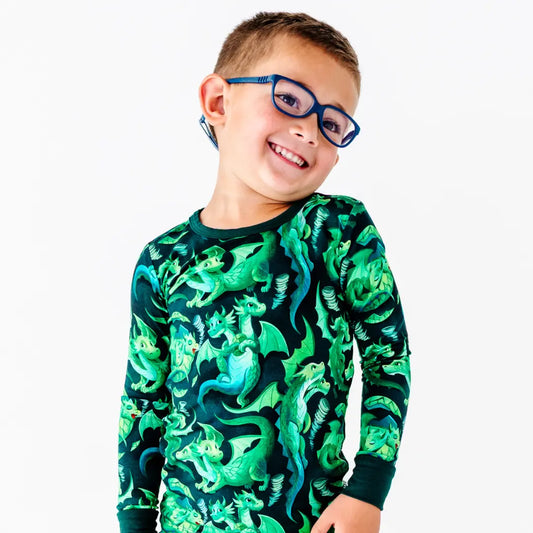 Child wearing a green dinosaur-patterned shirt on a white background