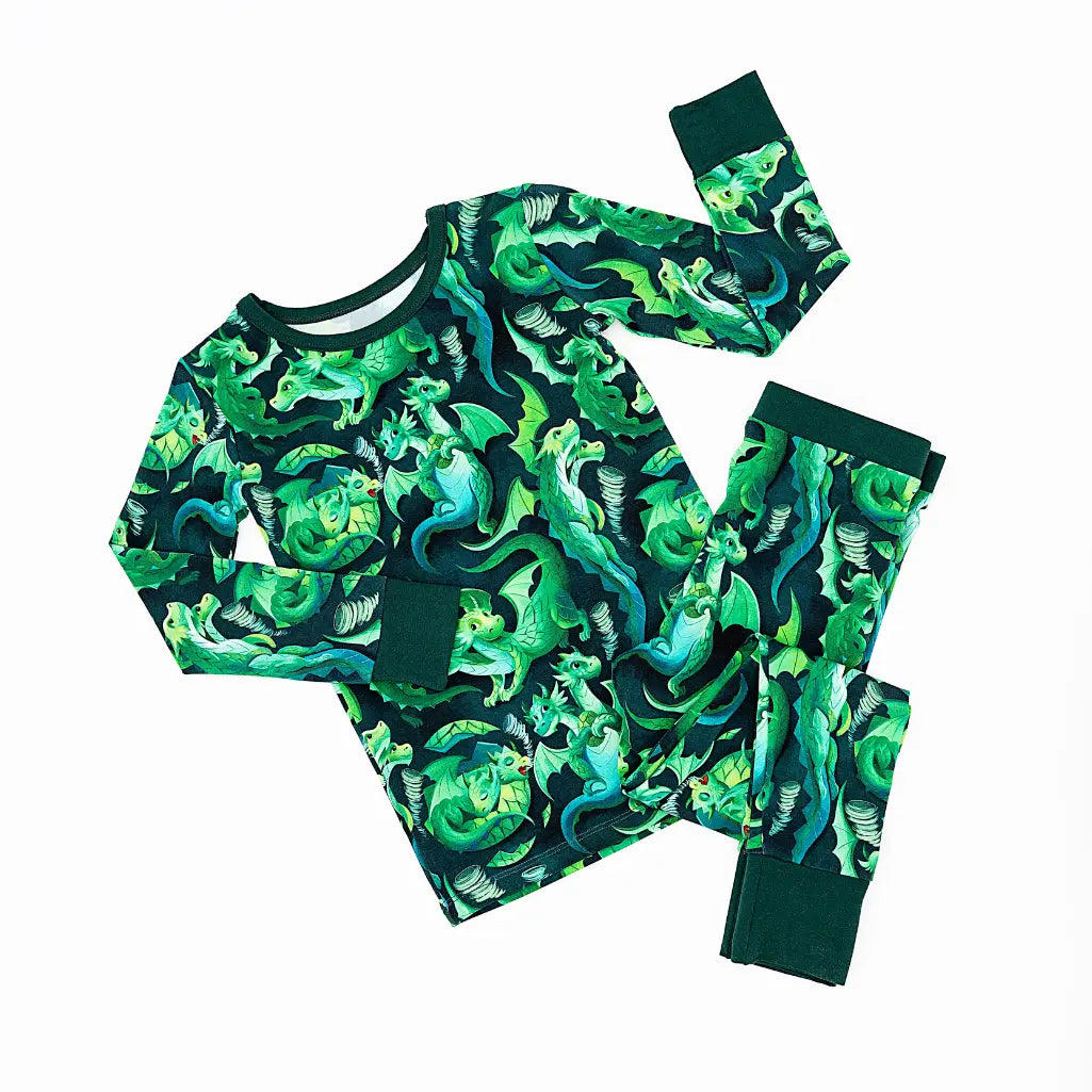 Children's pajama set with green dinosaur pattern on a white background
