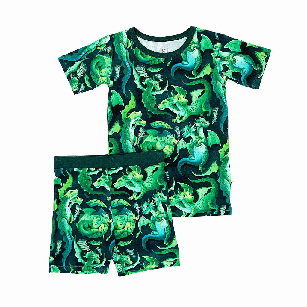 Children's pajama set with green dinosaur pattern on a white background