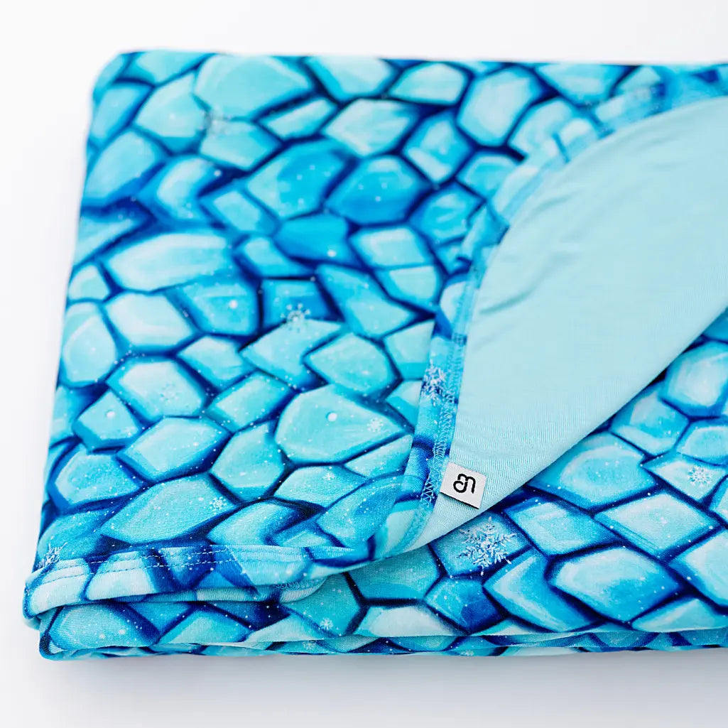 Two children in matching orange and yellow outfits reading a book on a light blue background.