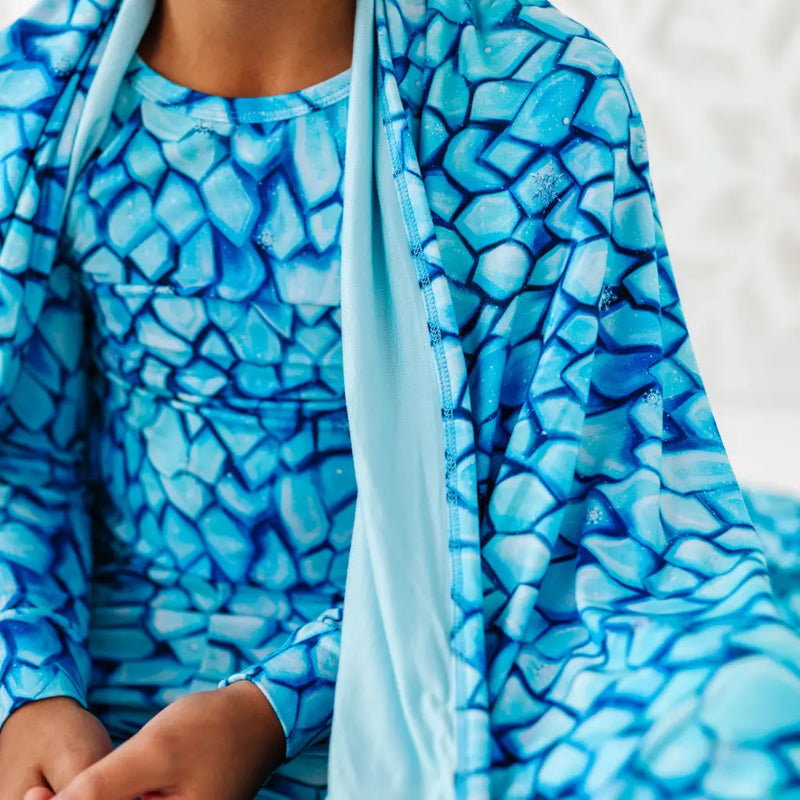 Person wearing a blue patterned outfit with a matching scarf.