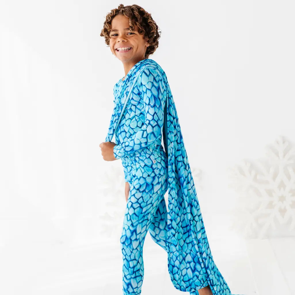 Child wearing a blue patterned onesie on a white background