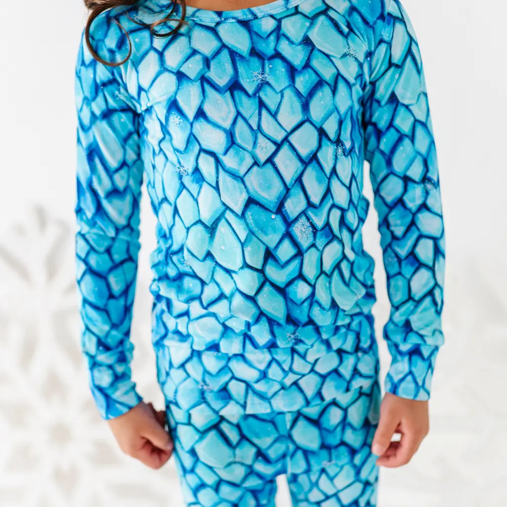 Child wearing a blue mosaic patterned outfit on a white background