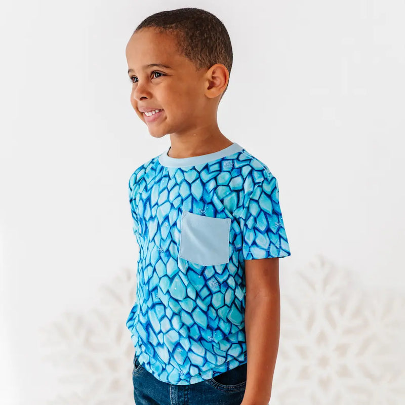 Child wearing a blue patterned shirt with a white background