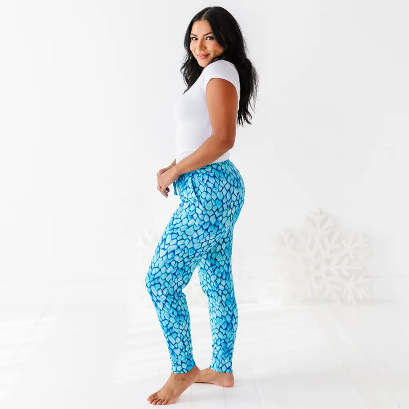 Woman wearing blue patterned leggings and a white top on a white background