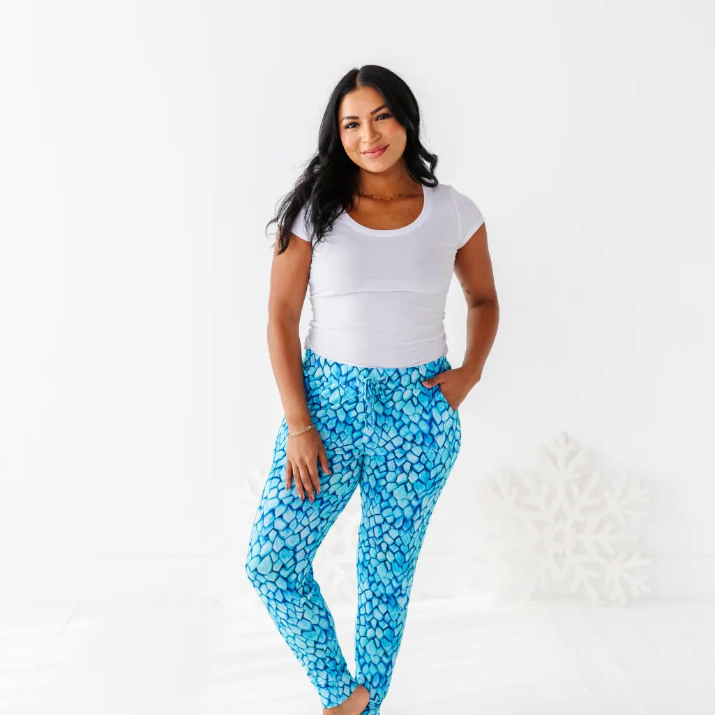 Woman wearing a white top and blue patterned pants on a white background