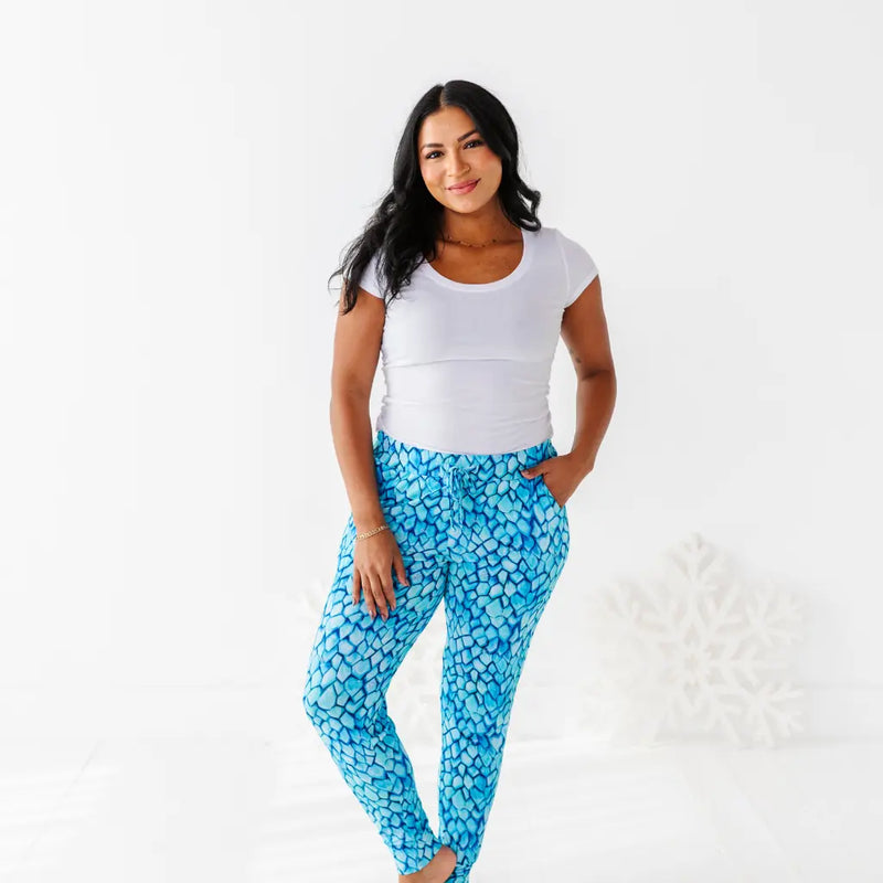 Woman wearing a white top and blue patterned pants on a white background