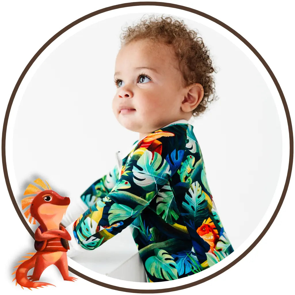 Baby wearing a colorful tropical-themed onesie with a cartoon dragon on a white background