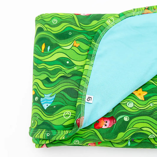Folded fabric with green wavy pattern and blue interior on a white background