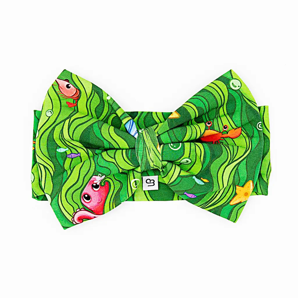 Green patterned bow tie with cartoon characters on a white background