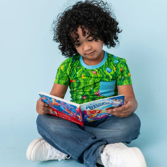 Child reading a book with a blue background
