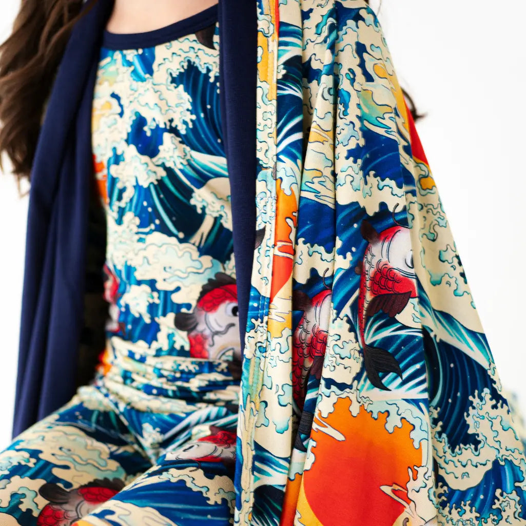 Colorful kimono with wave design draped over a person on a white background