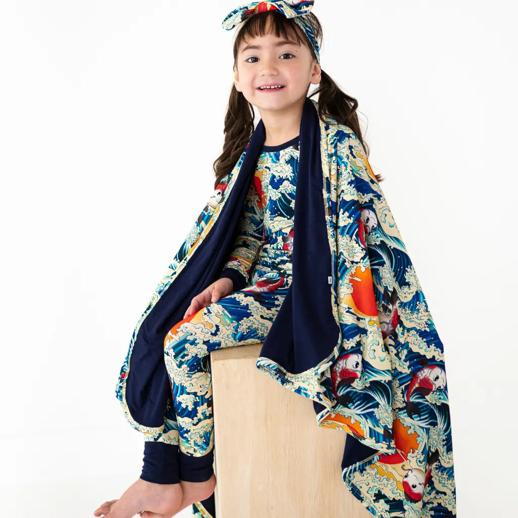 Child wearing a colorful kimono-style outfit with a white background