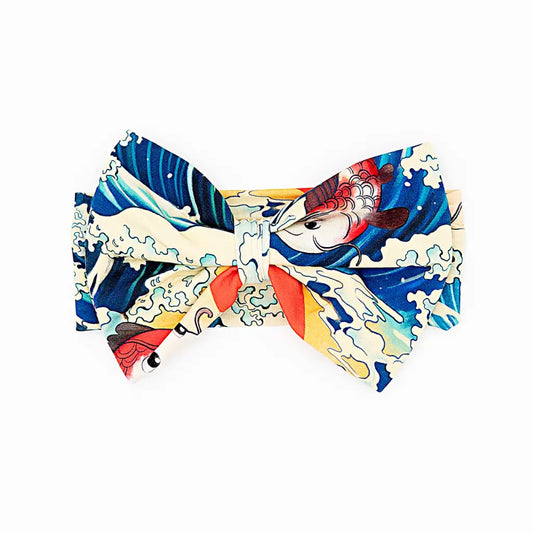 Colorful bow tie with a design of fish and waves on a white background