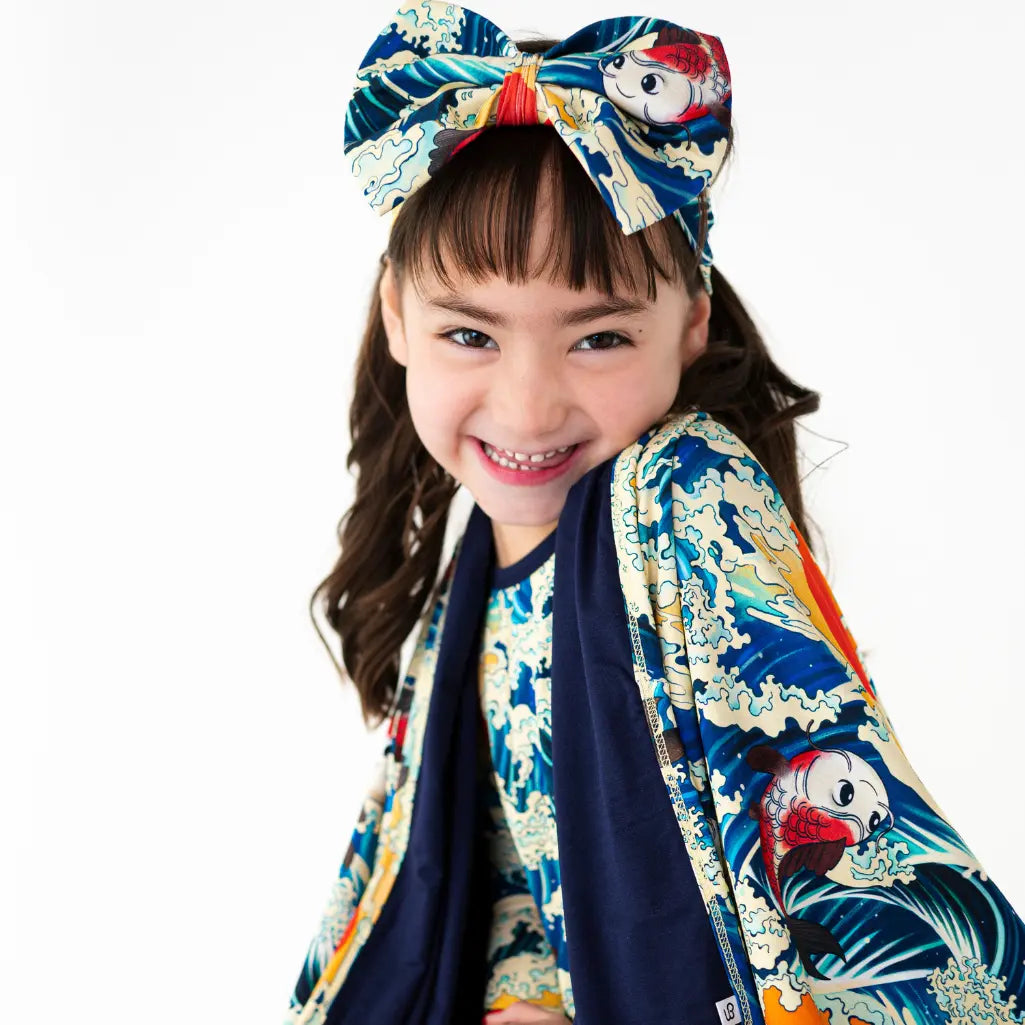 Child wearing a colorful kimono with a large bow on a white background