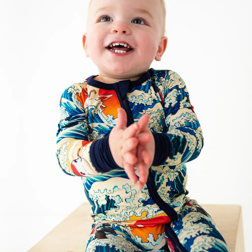 Baby wearing a colorful rash guard with a white background