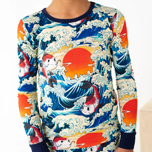 Colorful long-sleeve shirt with fish and wave design on a white background