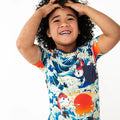 Child wearing a colorful shirt with a fish design on a white background